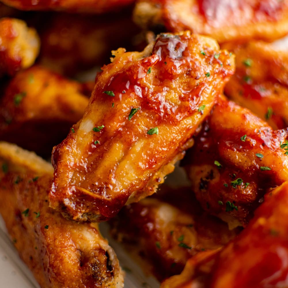 Close up on spicy delicious chicken wings with a green seasoning